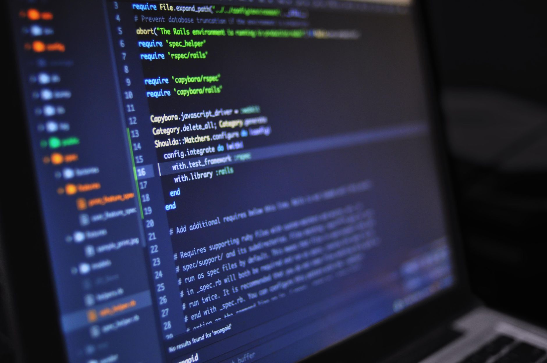 Un portátil con un editor de código abierto junto a una vista previa de una página web de estilo minimalista.
